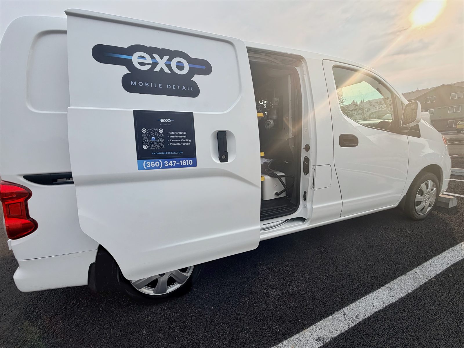 The Exo Mobile Detail van with its side door open, showing the water tank and equipment carried on board